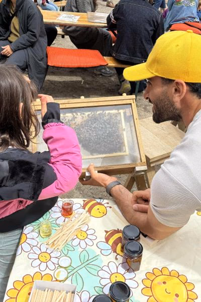 Founder showing an observation frame to a child at a workshop table